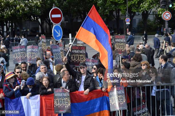 Man in the crowd waves a flag as French President Francois Hollande speaks during the commemoration of the 102nd anniversary of The Armenian Genocide...