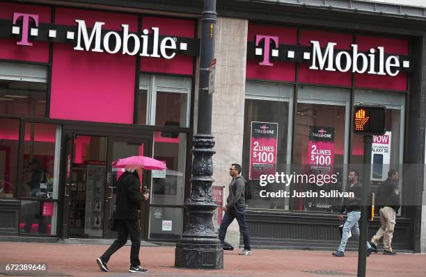 Pedestrians walk by a T-Mobile store on April 24, 2017 in San Francisco, California. T-Mobile will report first quarter earnings today after the...