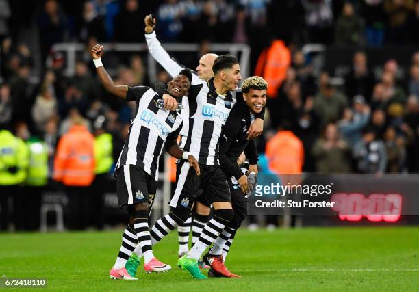 Christian Atsu, Ayoze Perez and DeAndre Yedlin of Newcastle United celebrate victory and promotion after the Sky Bet Championship match between...