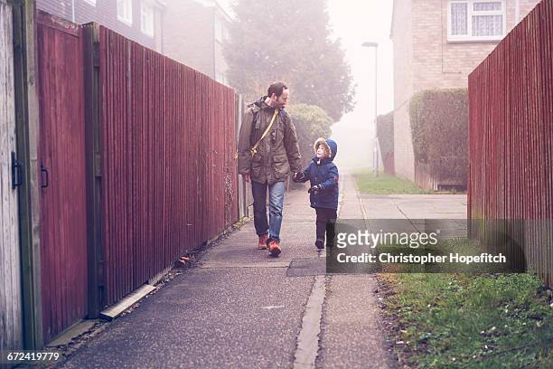 father and son walking to school - leanincollection father photos et images de collection