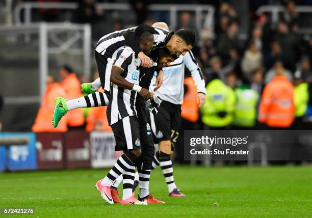 Christian Atsu, Ayoze Perez and DeAndre Yedlin of Newcastle United celebrate victory and promotion after the Sky Bet Championship match between...