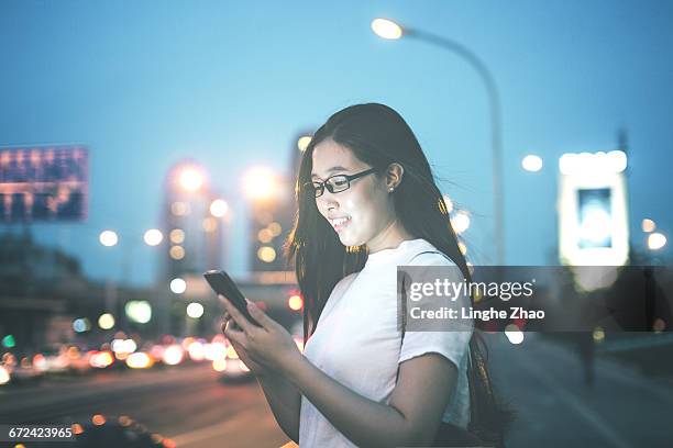 woman using mobile phone at night - linghe zhao stock pictures, royalty-free photos & images