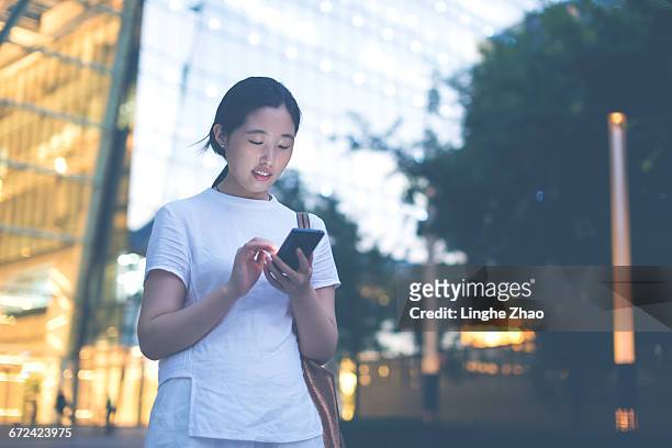 woman using mobile phone at night - linghe zhao stock pictures, royalty-free photos & images