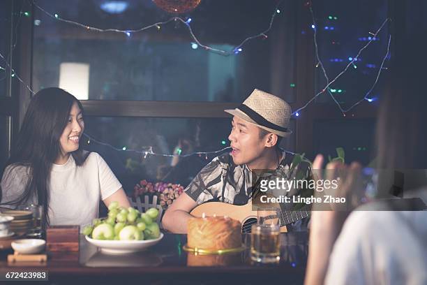 young man playing guitar in party - linghe zhao stock pictures, royalty-free photos & images