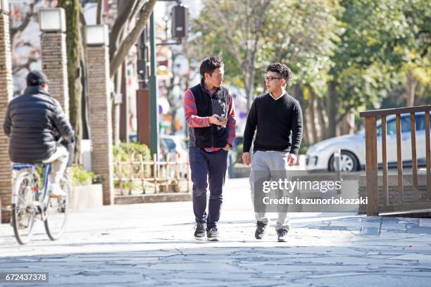 wandeling van twee jonge mannen - 一緒 stockfoto's en -beelden