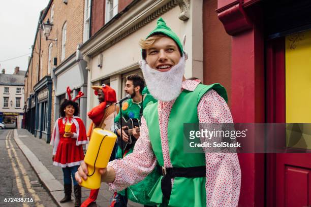 christmas charity buskers - christmas elf stock pictures, royalty-free photos & images
