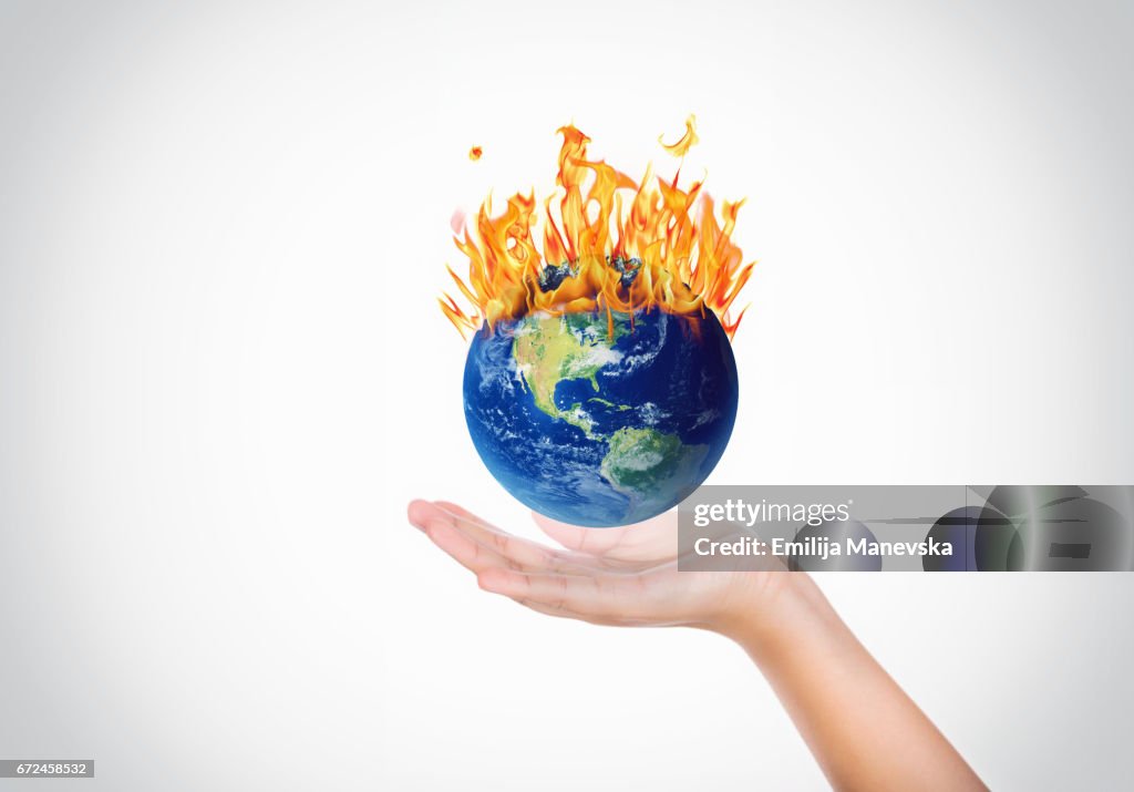Hands holding a globe on fire