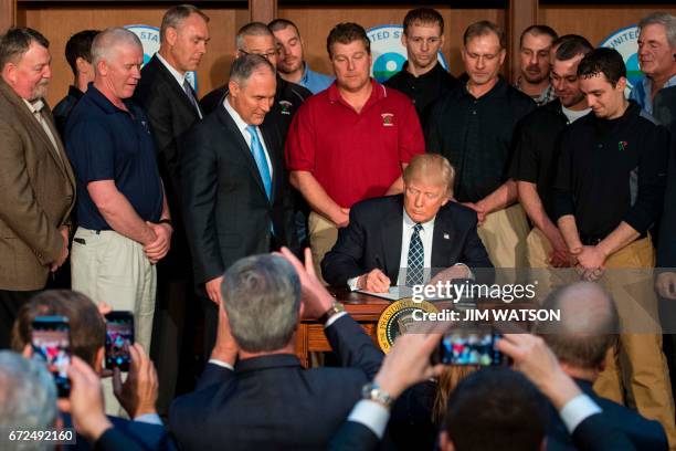 Surrounded by miners from Rosebud Mining, US President Donald Trump signs he Energy Independence Executive Order at the Environmental Protection...