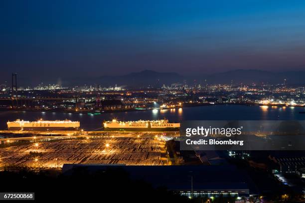 Hyundai Motor Co. Vehicles bound for export await shipment in front of a Eukor Car Carriers Inc. Roll-on/roll-off cargo ship, left, as a Wallenius...