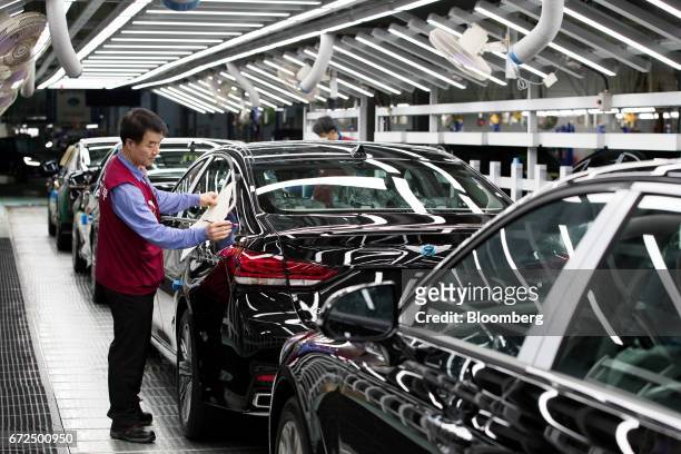 Employees perform final inspections on a Hyundai Motor Co. Genesis luxury sedan on the production line at the company's plant in Ulsan, South Korea,...