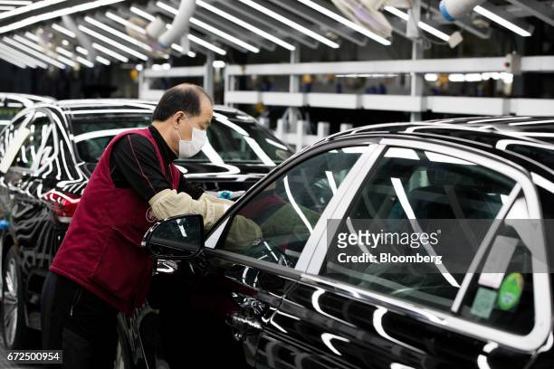 An employee performs final inspections on a Hyundai Motor Co. Genesis luxury sedan on the production line at the company's plant in Ulsan, South...