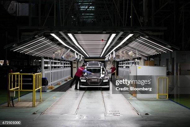Employees perform final inspections on Hyundai Motor Co. Genesis luxury sedans on the production line at the company's plant in Ulsan, South Korea,...