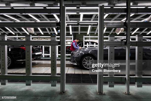 An employee make notes as he performs final inspections on a Hyundai Motor Co. Genesis luxury sedan on the production line at the company's plant in...