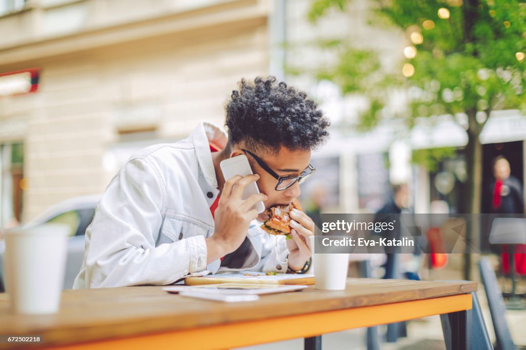 Young man having lunch in the city