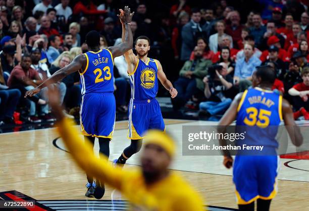 Stephen Curry of the Golden State Warriors celebrates a three point shot with Draymond Green against the Portland Trail Blazers during Game Four of...