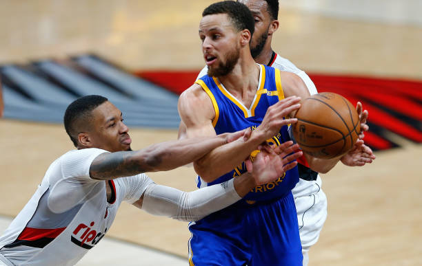 Stephen Curry of the Golden State Warriors is guarded by Damian Lillard of the Portland Trail Blazers during Game Four of the Western Conference...