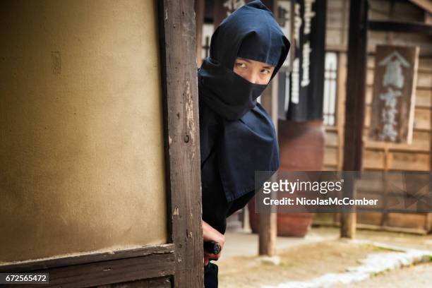 japanese ninja in black costume hiding in edo village - ninja weapon stock pictures, royalty-free photos & images