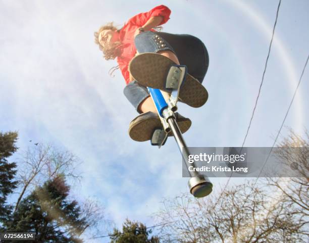 girl jumping on a pogo stick. - pogo stick stock pictures, royalty-free photos & images