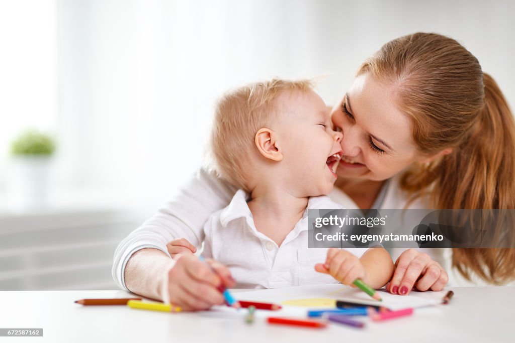 Mother with baby son with colored pencils