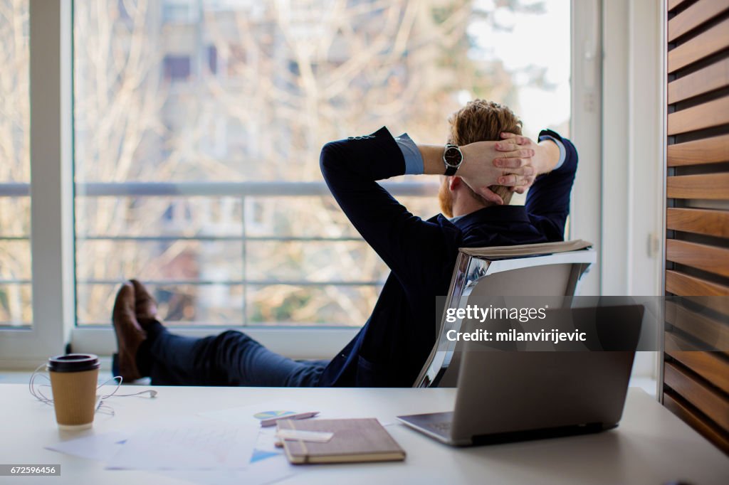 Businessman sitting in the office and looking through the window