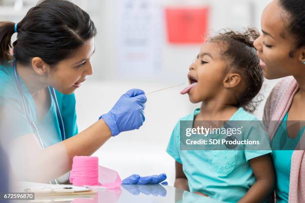 médecin examine jeune patient afro-américain - black woman tongue out photos et images de collection