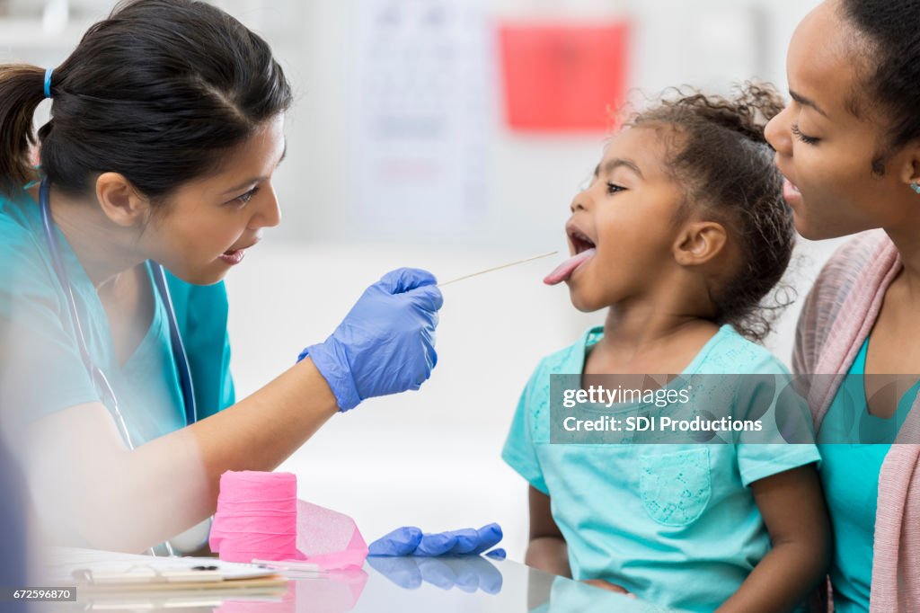 Doctor examines young African American patient