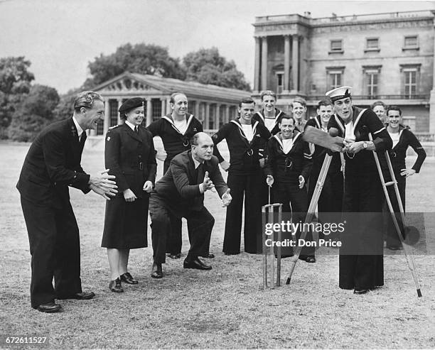 Entertainer Robert Easton plays wicket keeper to injured Royal Navy Able Seaman Parrot from HMS Surprise during a game of cricket at the Not...