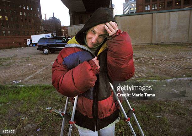 Homeless woman Joan Kimball stands beneath the Manhattan bridge where she lives November 20, 2001 in the Brooklyn borough of New York City. Economic...