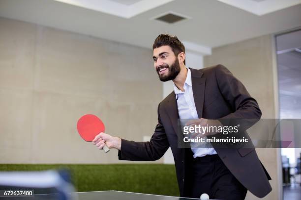 young businessman playing table tennis - office ping pong stock pictures, royalty-free photos & images