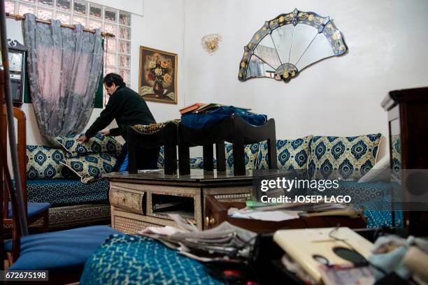 Man cleans-up a flat following a raid by members of the Catalan Regional Police in Barcelona on April 25, 2017 that led to the arrest of four men...