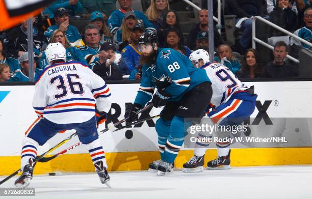 Brent Burns of the San Jose Sharks skates after the puck against Drake Caggiula and Connor McDavid of the Edmonton Oilers in Game Six of the Western...