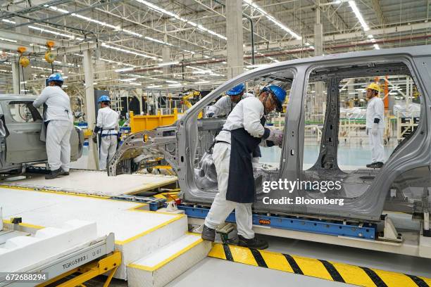 Employees work on a Mitsubishi Motors Corp. Sports utility vehicle on a production line at the company's plant in Cikarang, Indonesia, on Tuesday,...