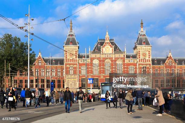 tourists walking thought the facade of centraal station amsterdam , holland, october 4, 2015. - 運河 stockfoto's en -beelden