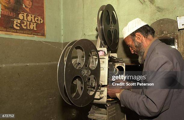 Movie projectionist Mohamed Yassin spools old celluloid films onto an antiquated movie projector November 21, 2001 at Kabul's newly reopened Bakhtar...