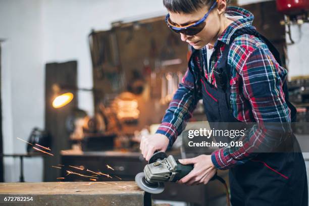 arbeider in een atelier met behulp van grinder - metal sanding stockfoto's en -beelden