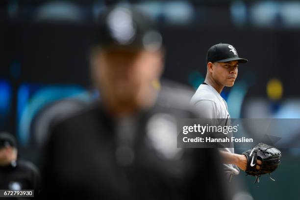 Jose Quintana of the Chicago White Sox looks on as pitching coach Don Cooper returns to the dugout following a trip to the mound during the game...