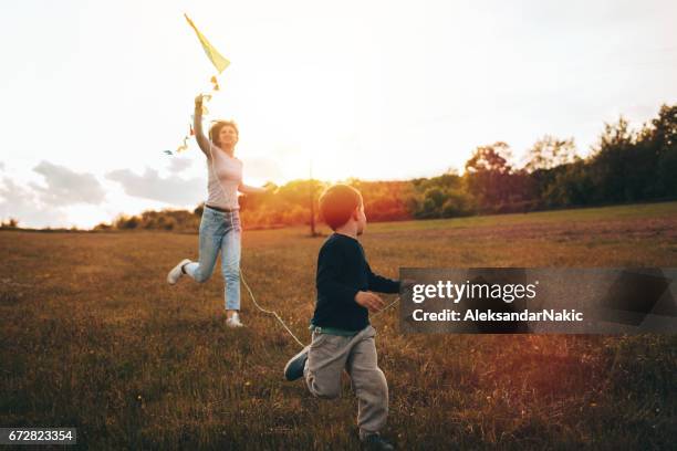 einen drachen mit meiner mutter laufen - drachen stock-fotos und bilder