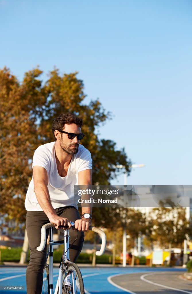 Man Running To Rides Confident Man Riding Bicycle On Running Track High-Res Stock Photo ...