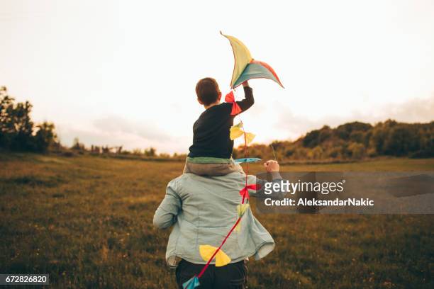 kite bereit für fliegen - mann mit kind auf den schultern stock-fotos und bilder