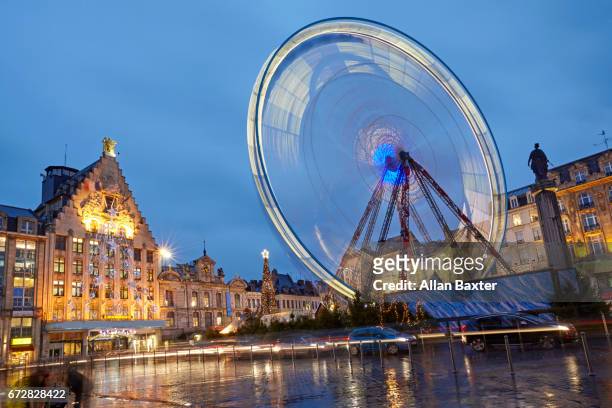 ferris wheel in christmas market illuminated at dusk central lille - france lille stock pictures, royalty-free photos & images
