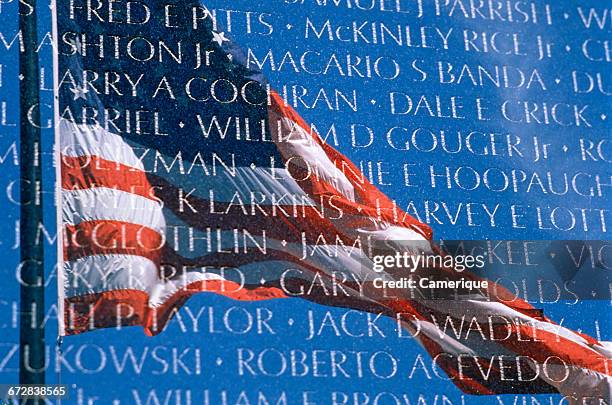 The flag of the United States reflected in the Vietnam Veterans Memorial in Washington, DC, 13th November 1982.