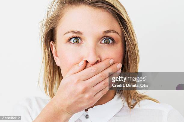 young woman with hand over her mouth, surprised - hands covering mouth stock pictures, royalty-free photos & images