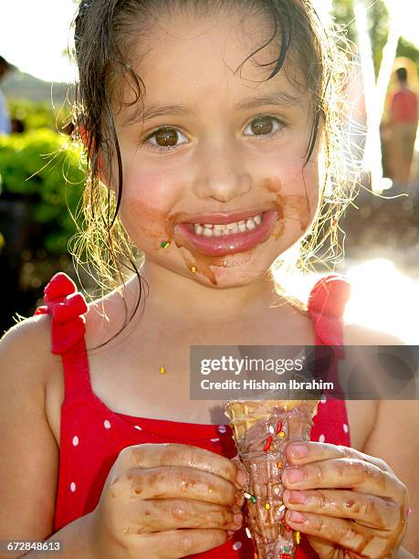 young girl eating and licking ice cream cone. - girl eating messy ice cream cone stock-fotos und bilder