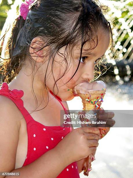 young girl eating and licking ice cream cone. - girl eating messy ice cream cone stock-fotos und bilder