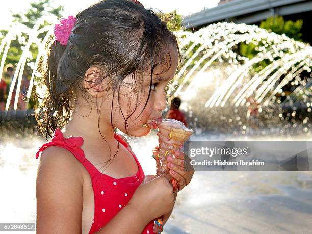 young girl eating and licking ice cream cone. - girl eating messy ice cream cone stock-fotos und bilder