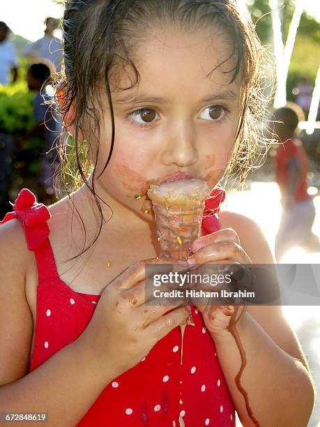 young girl eating and licking ice cream cone. - girl eating messy ice cream cone stock-fotos und bilder