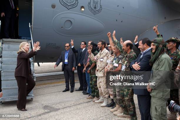 Secretary of State Hillary Rodham Clinton meets Libyan rebel fighters at the steps of her C-17 military transport upon her arrival on October 18,...