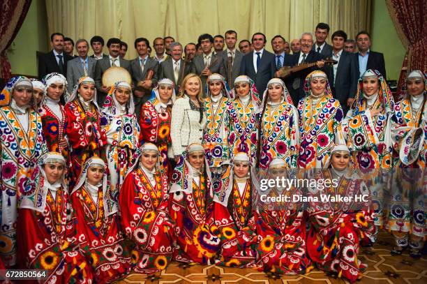 Secretary of State Hillary Rodham Clinton poses with perfumers dressed in traditional costume of Tajikistan on October 21, 2011 in Dushanbe,...