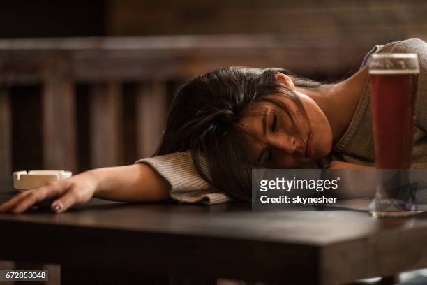 young drunk woman sleeping on the table in a pub. - binge drinking stock pictures, royalty-free photos & images