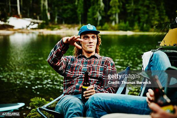 man in discussion with friends while camping - men friends beer outside stock-fotos und bilder